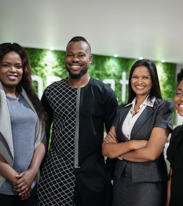Portrait of a diverse group of smiling young African businesspeople standing together in the lobby of a modern office